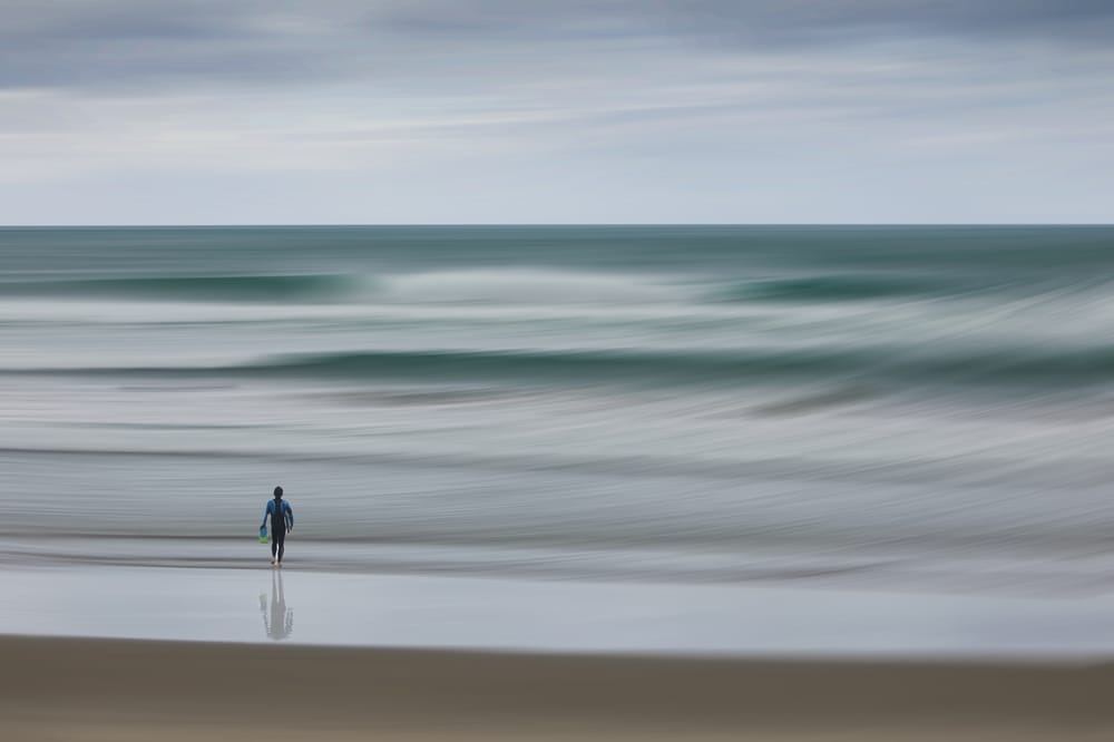 Surfer and a Stormy Whangamata post image