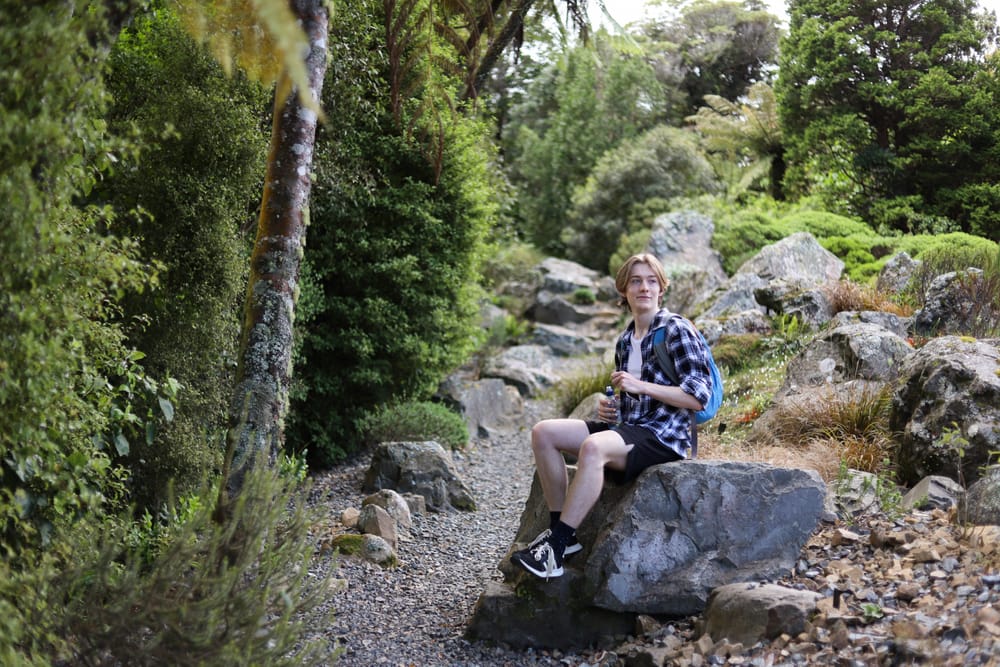 Hiker sitting on a rock post image