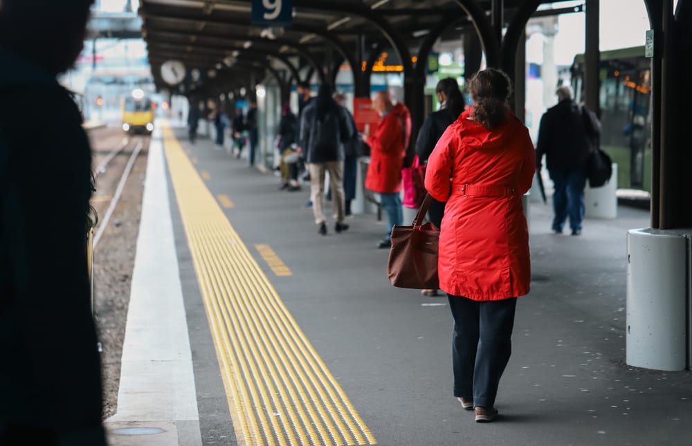 Commuters waiting at train station platform post image