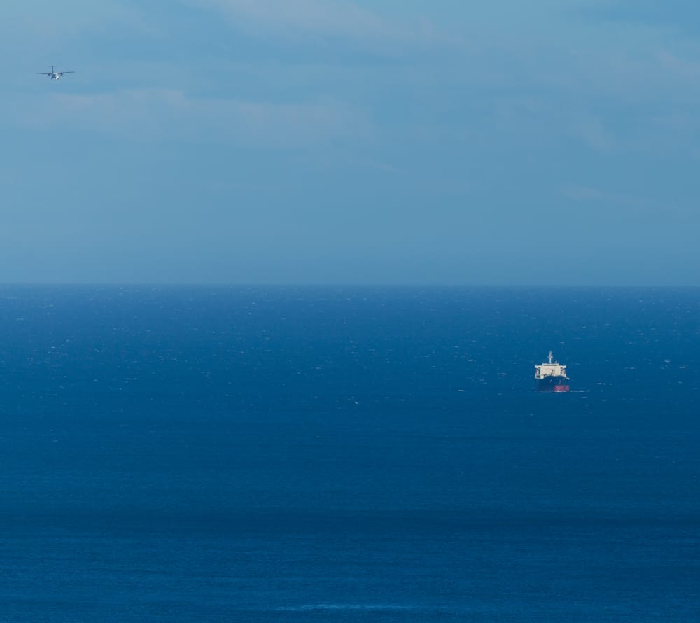 Ship and plane over open ocean post image