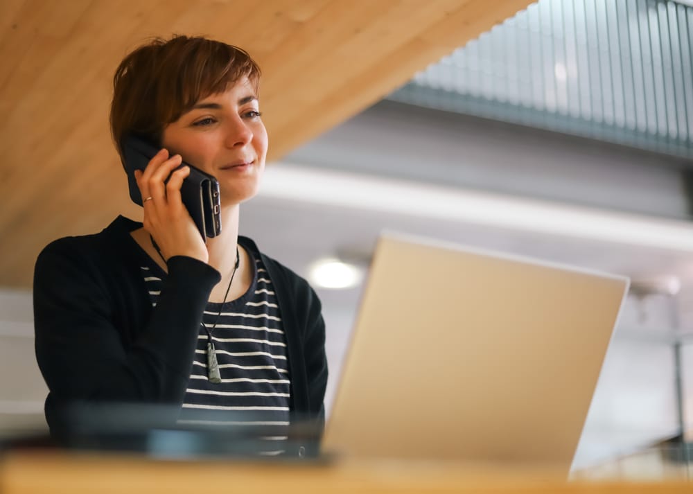 Professional woman smiling during phone call post image