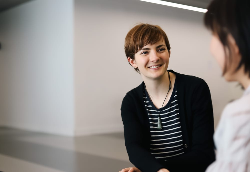 Professional woman smiling during a discussion post image