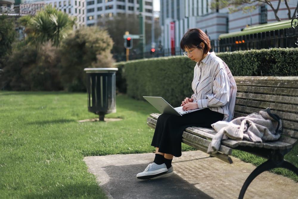 Young professional working on laptop outdoors post image