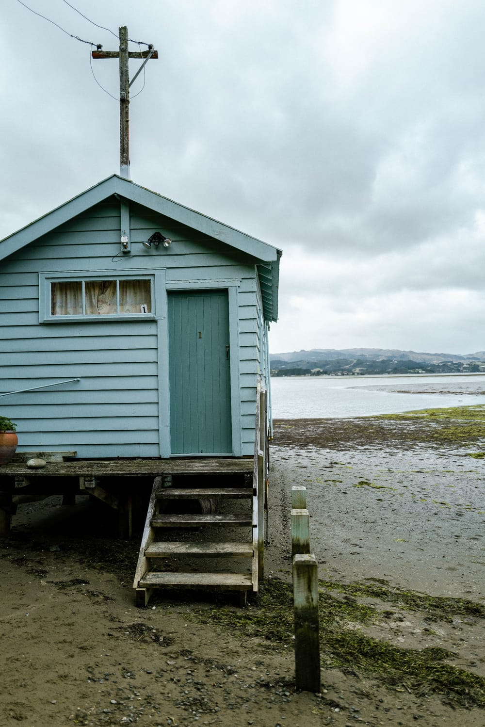 Blue cabin by coastal shore post image