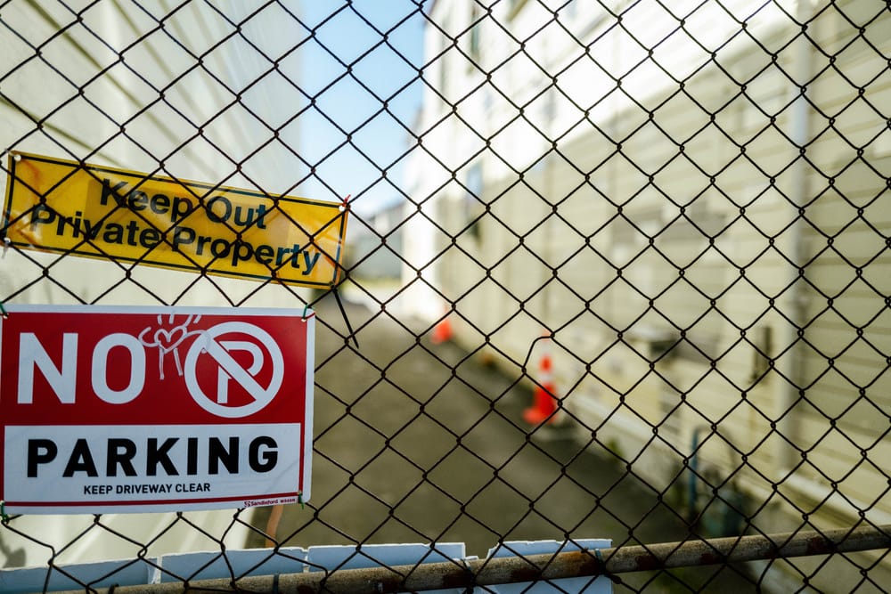 Chain-link fence with warning signs post image