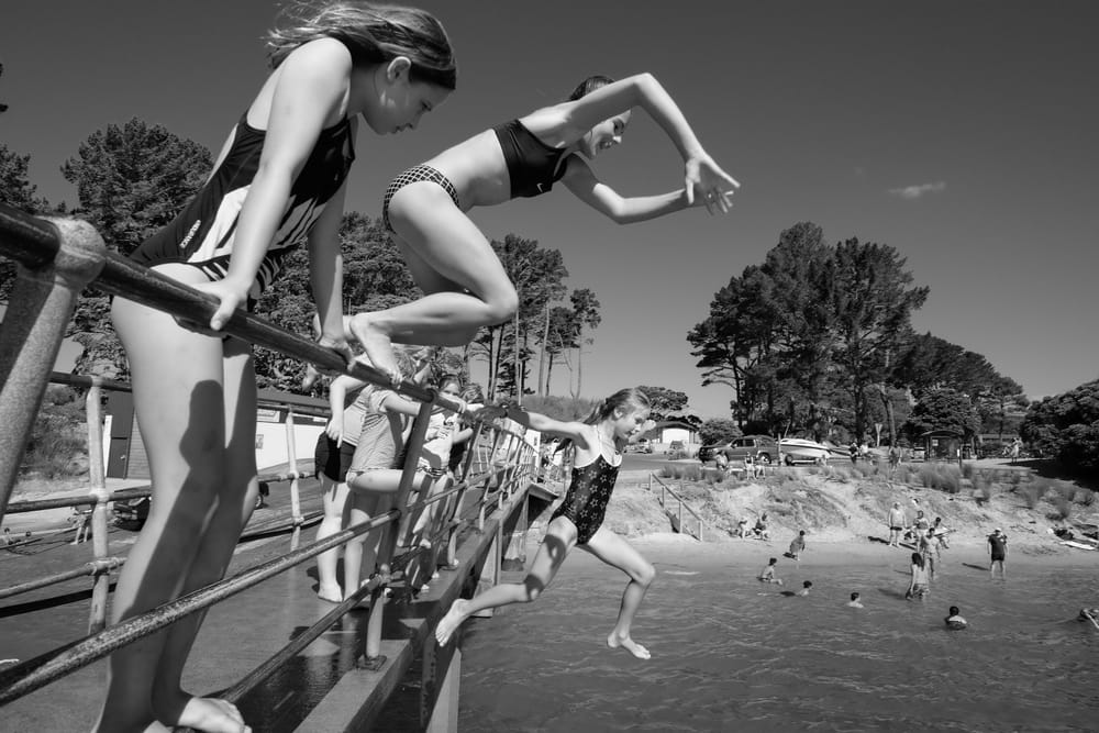 Children jumping from the railing into the water post image