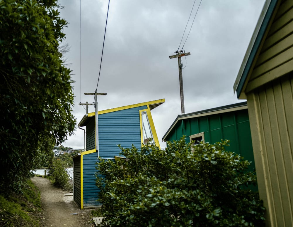 Colourful houses and pathway under stormy sky post image