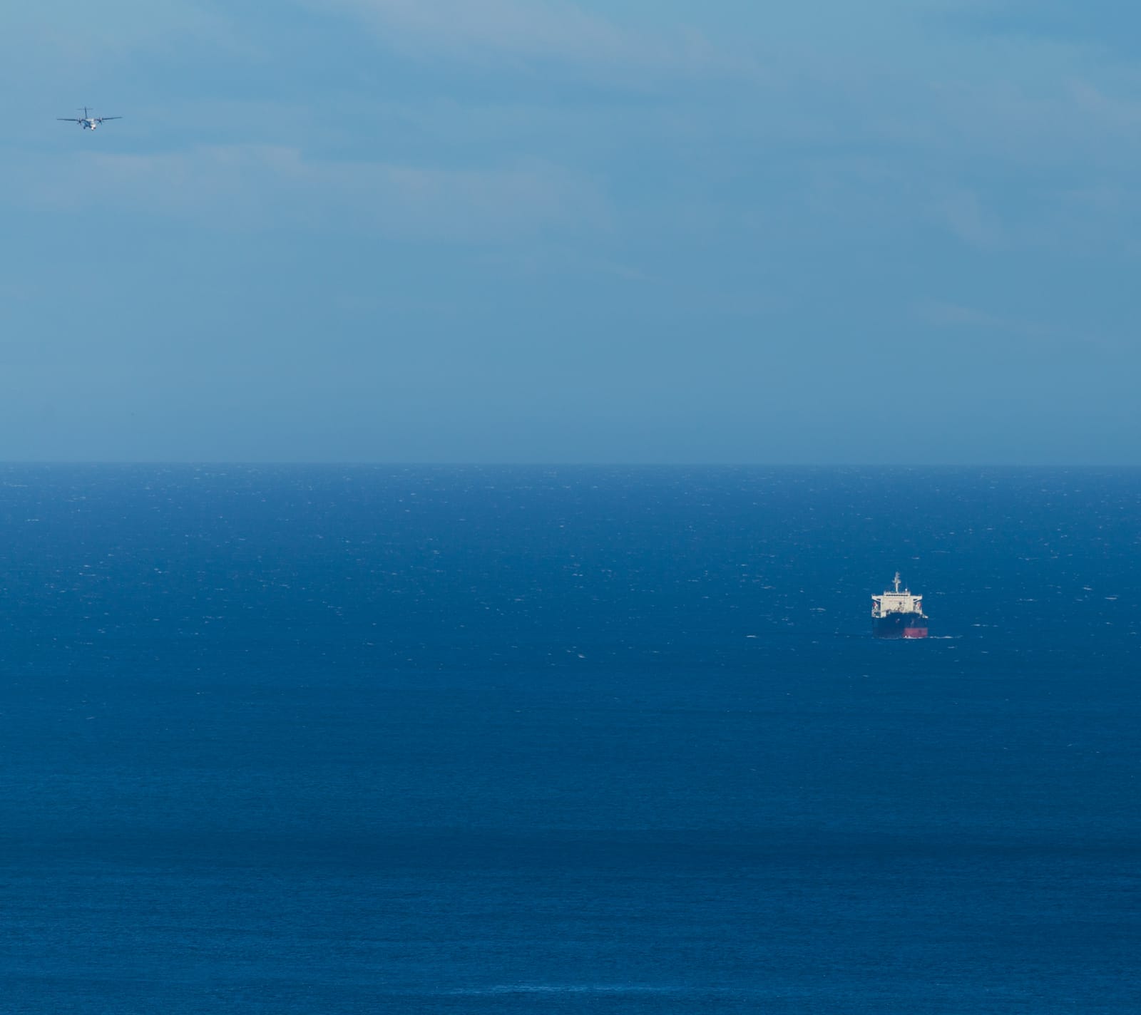Ship and plane over open ocean