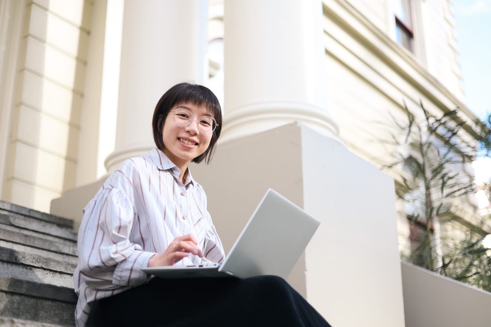 Smiling woman using laptop outdoors