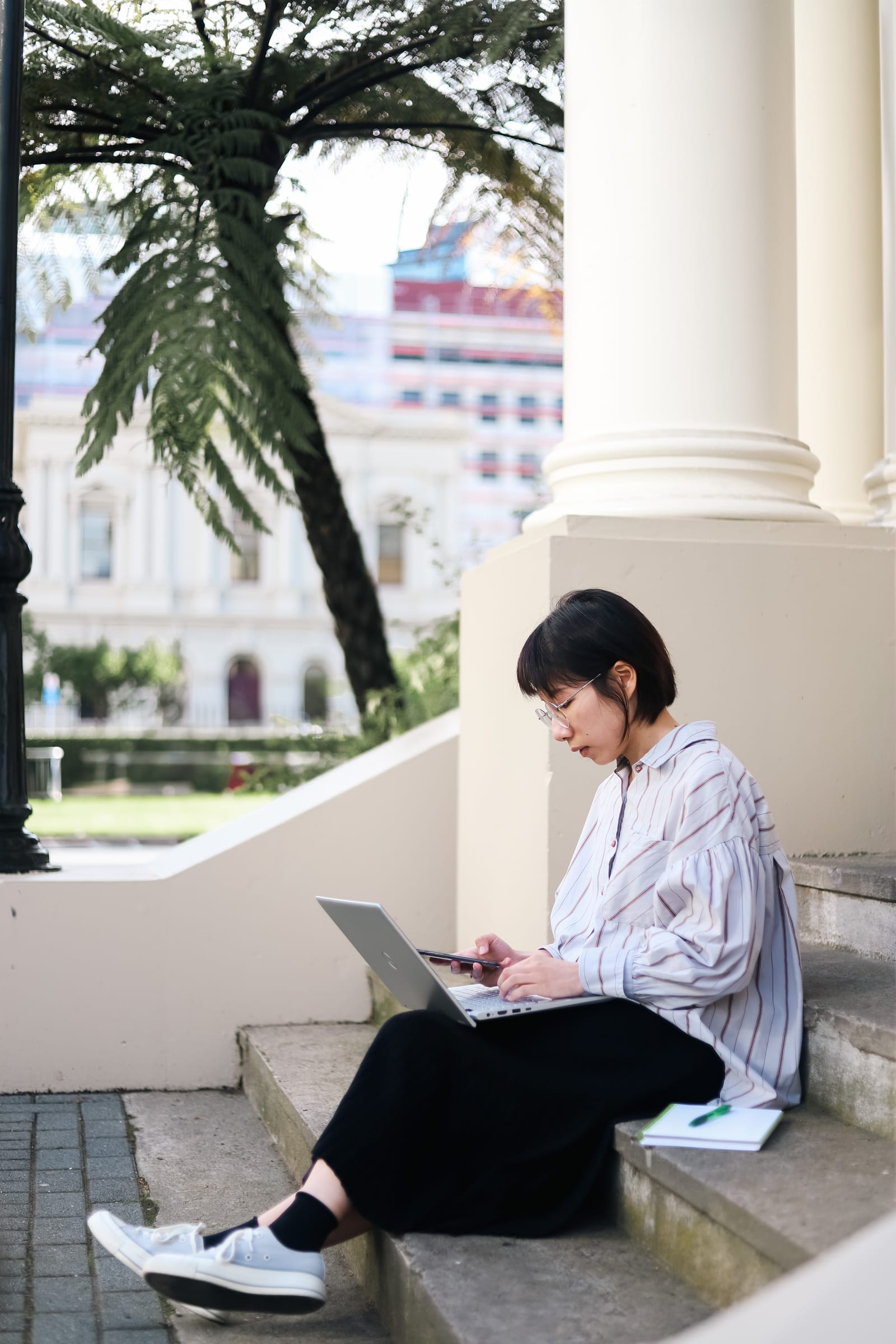 Woman working on laptop outdoors