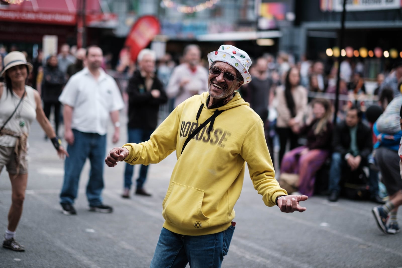 Dancing man in a yellow hoodie at a street festival