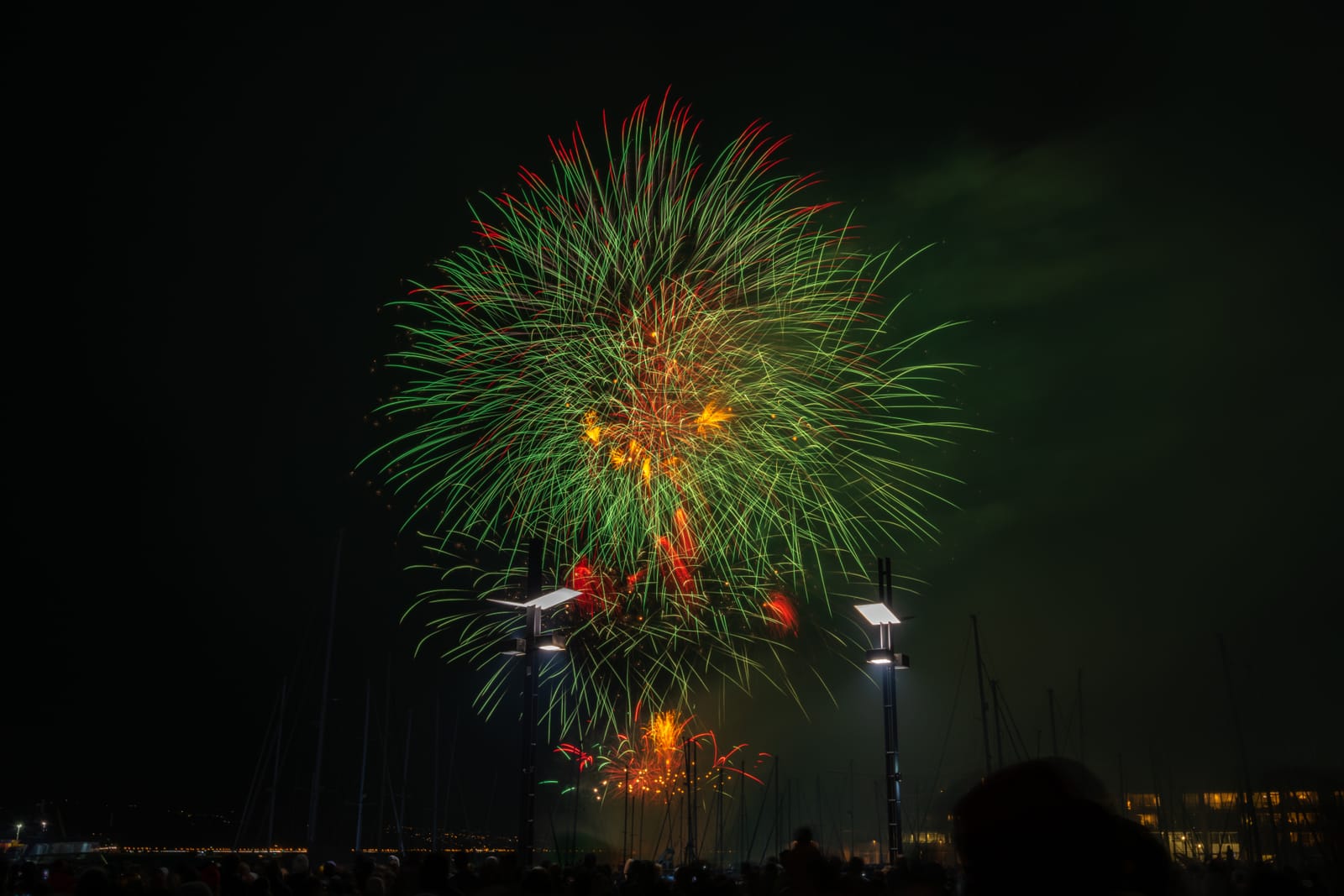 Green and orange fireworks over harbour