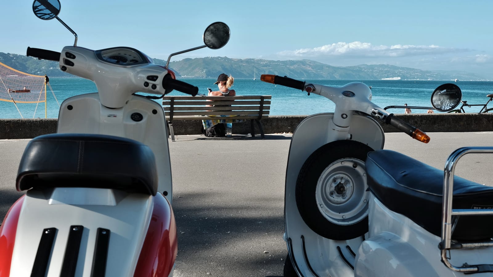 Scooters and a bench by the coastal promenade