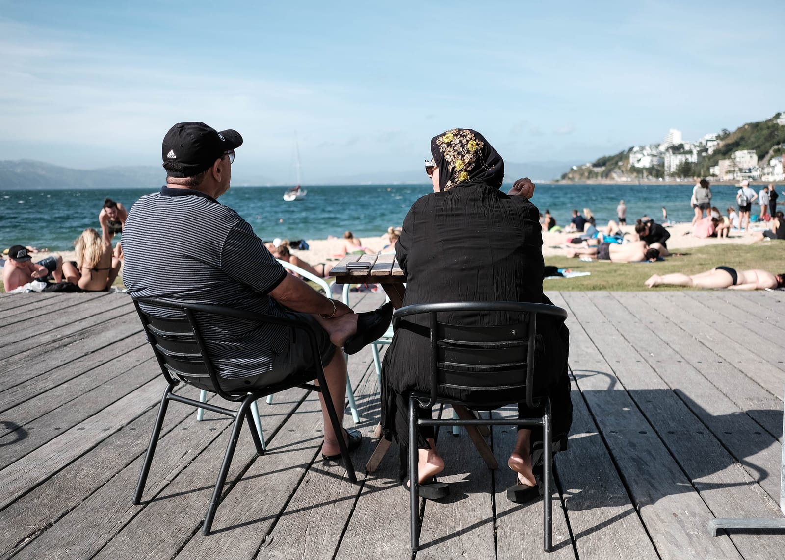 Two seated figures on a sunny deck