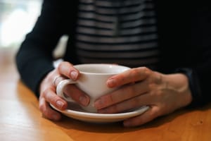 Hands holding cup of coffee post feature image