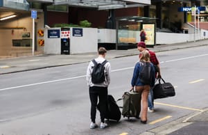 Travelers with luggage in city street post feature image