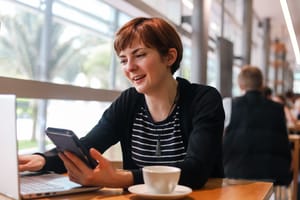 Woman chatting on phone at cafe table post feature image
