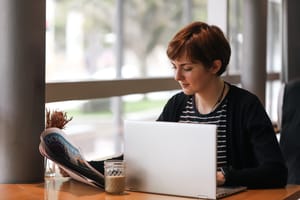 Woman reading newspaper in cafe post feature image