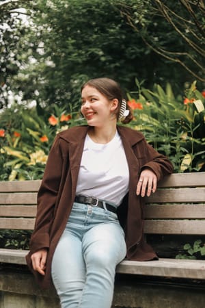 Girl sits on a wooden bench post feature image