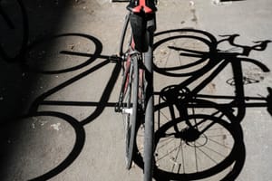 Bicycle and shadow on sunlit pavement post feature image