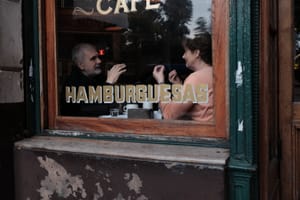 Café window with two people in conversation post feature image