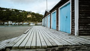 Row of boathouses with blue doors and coastal view post feature image
