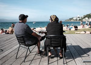 Two seated figures on a sunny deck post feature image